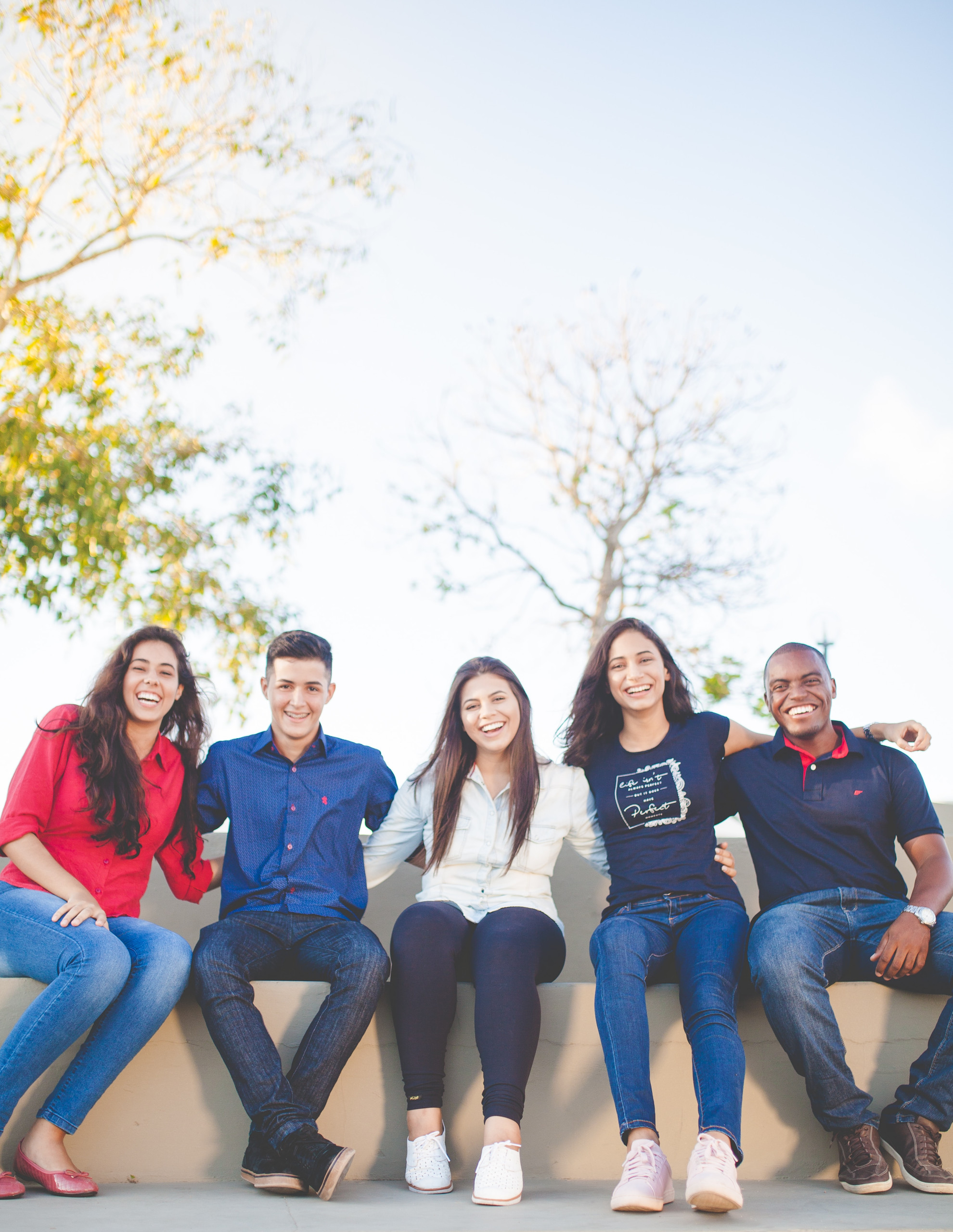 people in a group sitting down outside smiling
